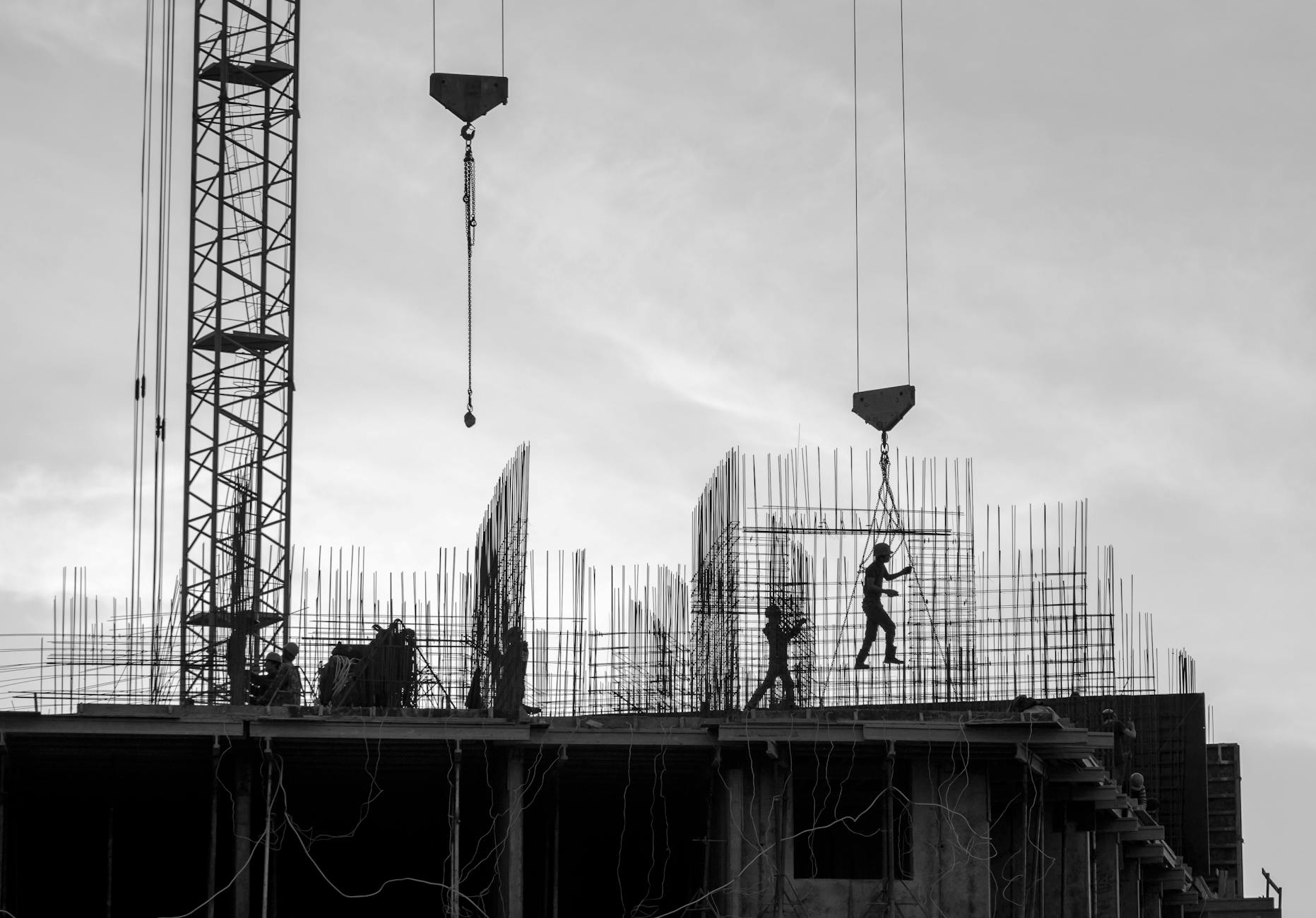 grayscale photo of people working on a construction site